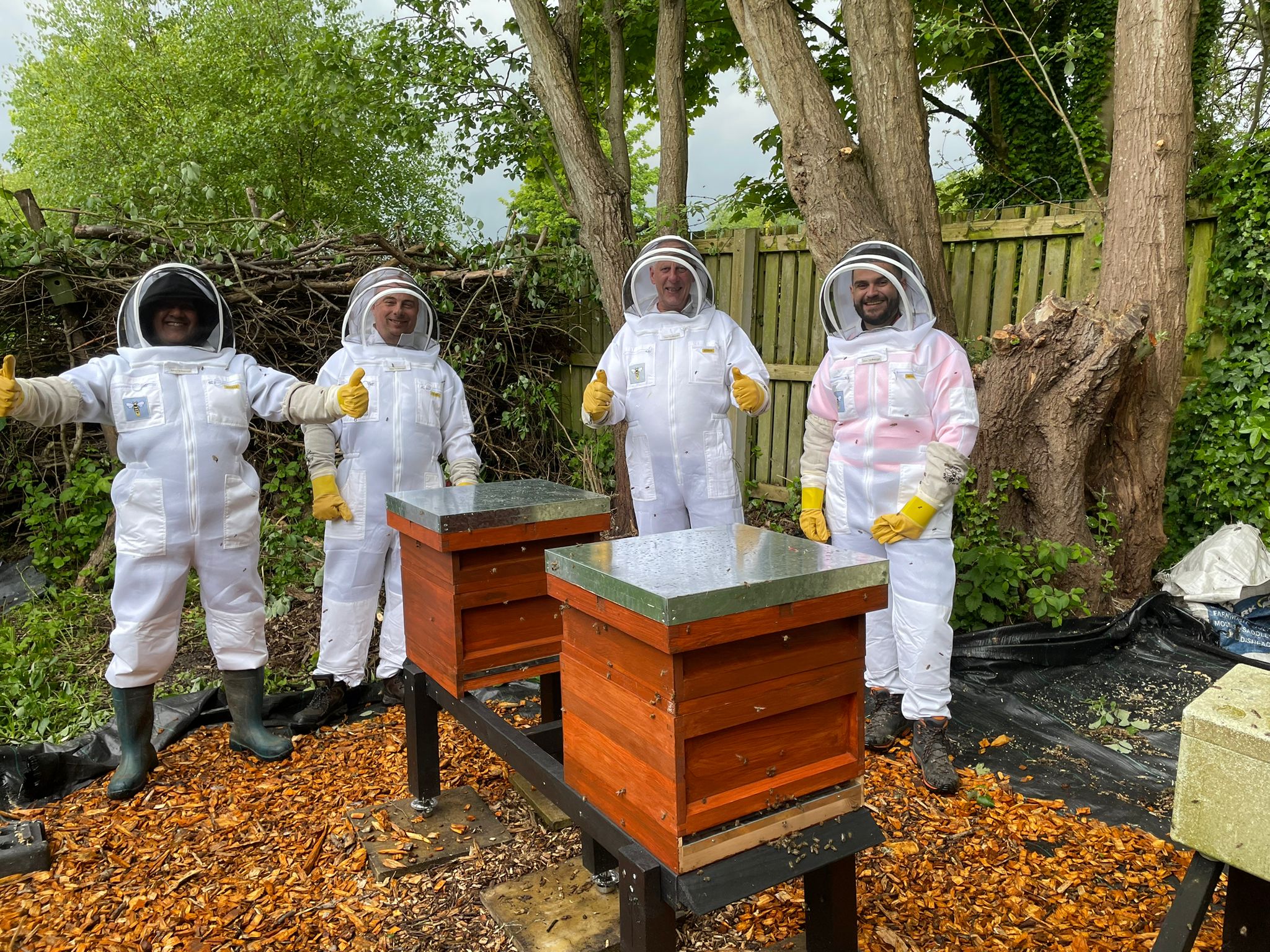 Members standing beside two installed beehives at the allotment apiary
