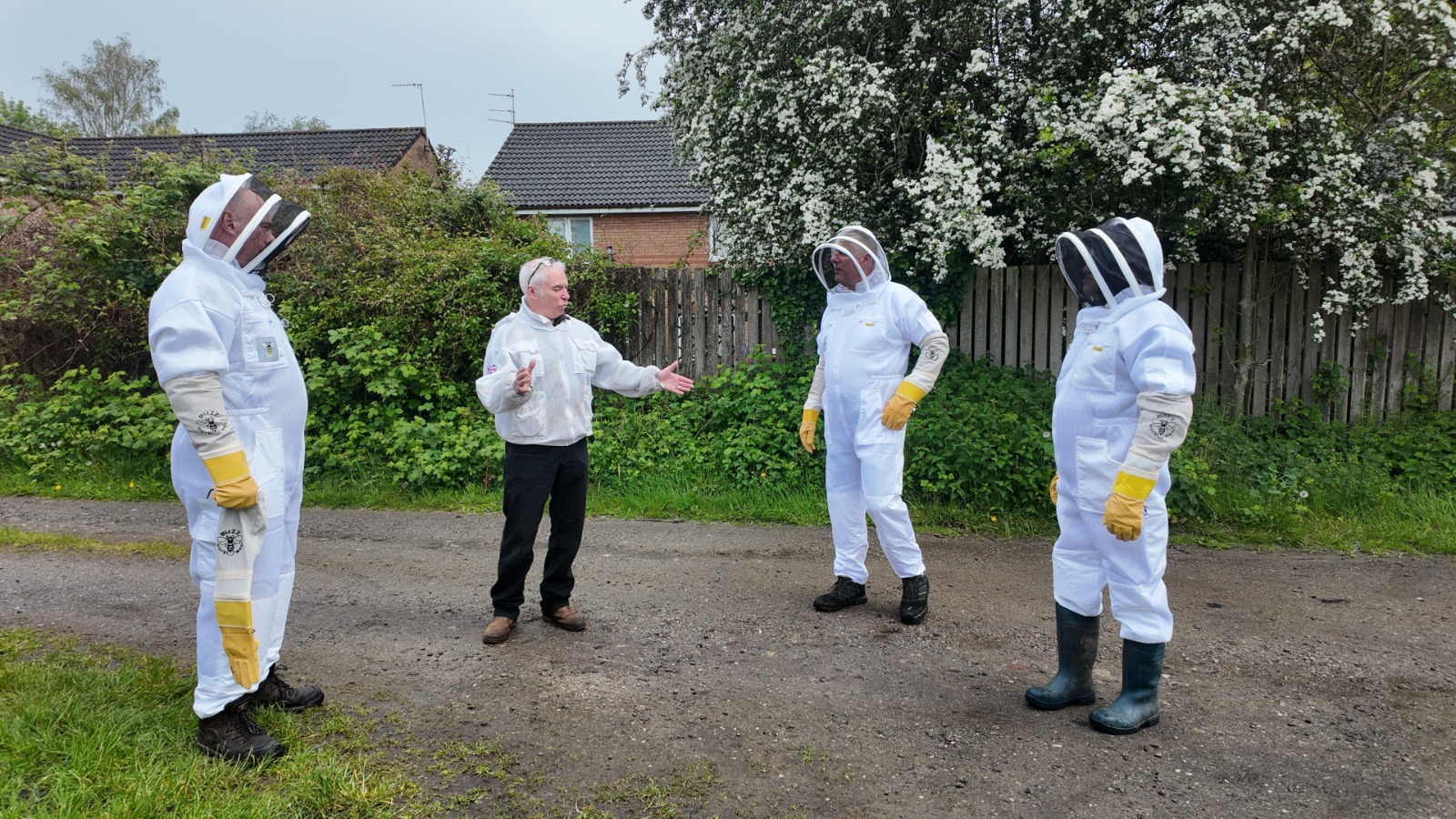 Beekeeping briefing with members wearing protective suits